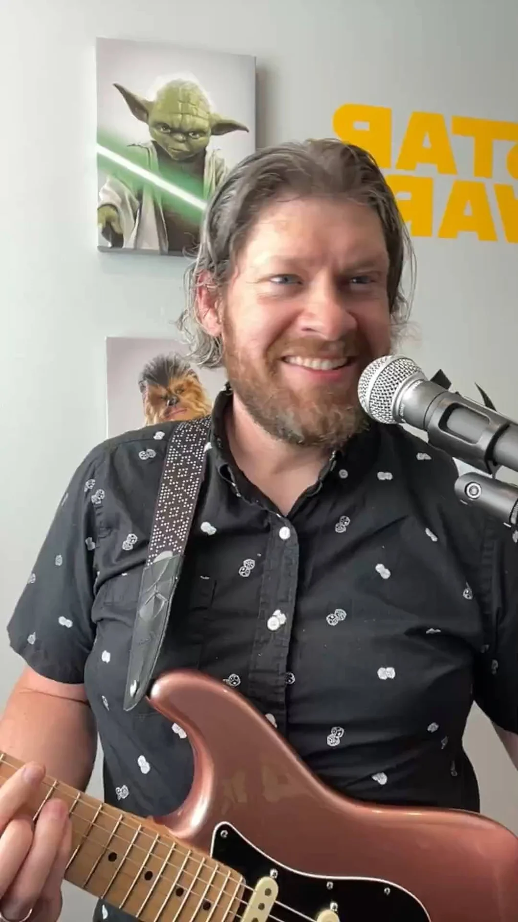 Brad with an acoustic guitar and microphone at home