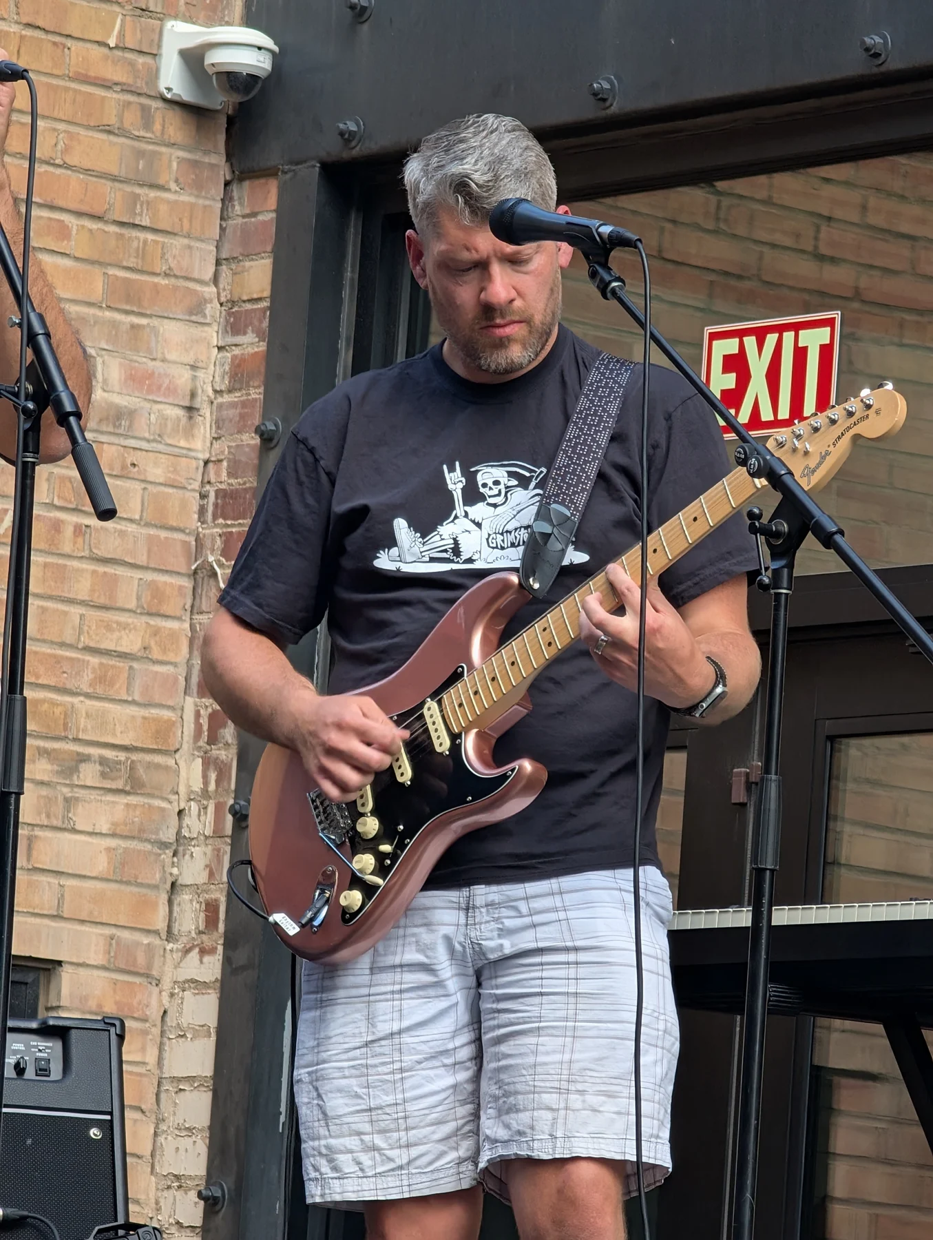 Brad playing electric guitar at an outdoor performance